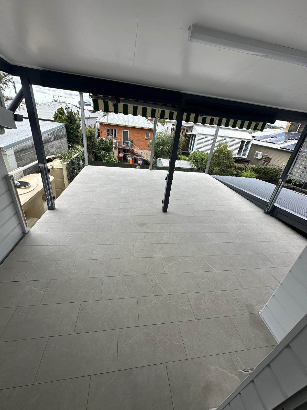 Large covered deck tiled in light grey outdoor floor tiles