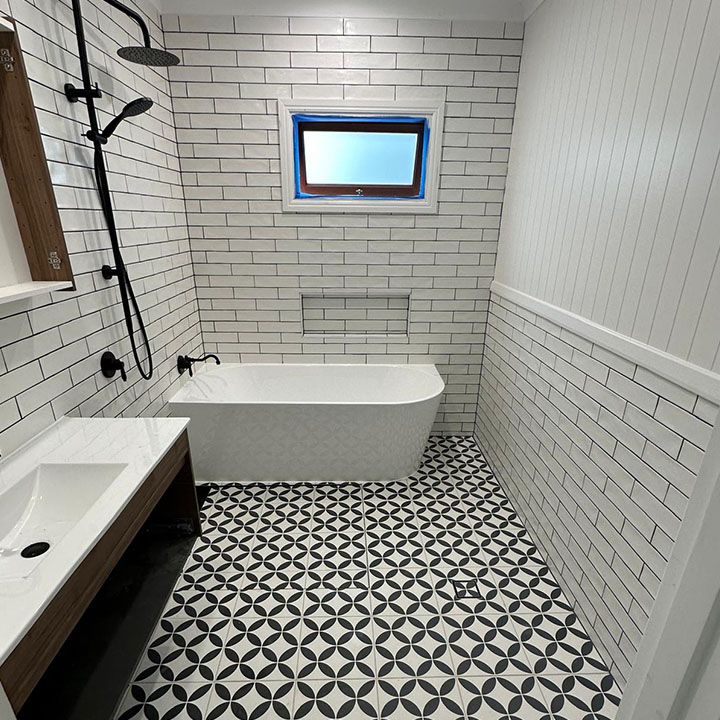 Bathroom with white subway wall tiles, freestanding bath and black and white patterned floor